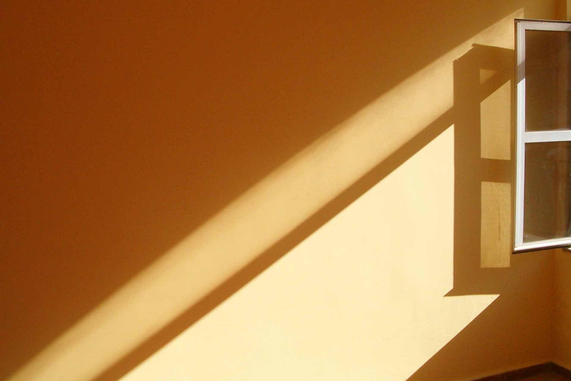 Gemalte Wand mit Lichstrahlen vom Fenster